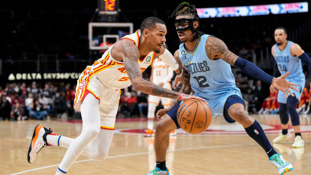 Atlanta Hawks guard Dejounte Murray dribbles past Memphis Grizzlies guard Ja Morant.